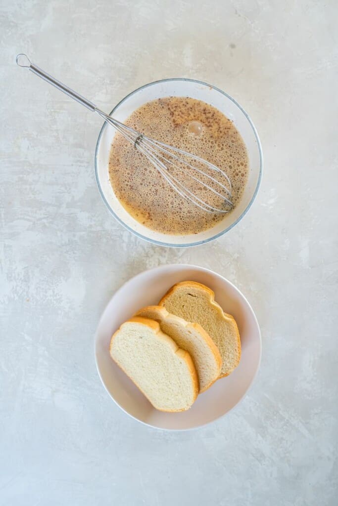 Dipping bread in a mixture of milk, eggs, sugar, and vanilla. Cinnamon sugar in second bowl.