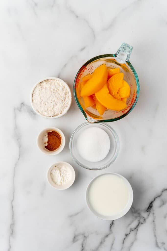 Ingredients needed to prepare a peach cobbler in an air fryer.