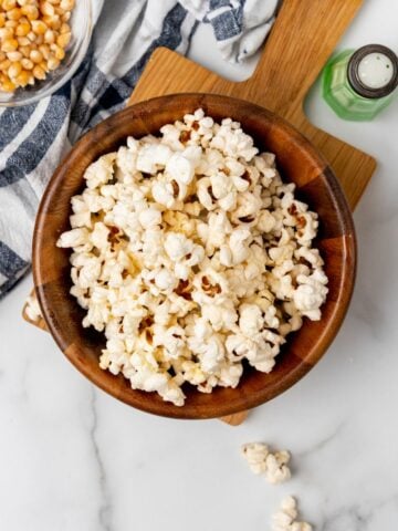 Overhead view of popcorn in a wooden bowl.