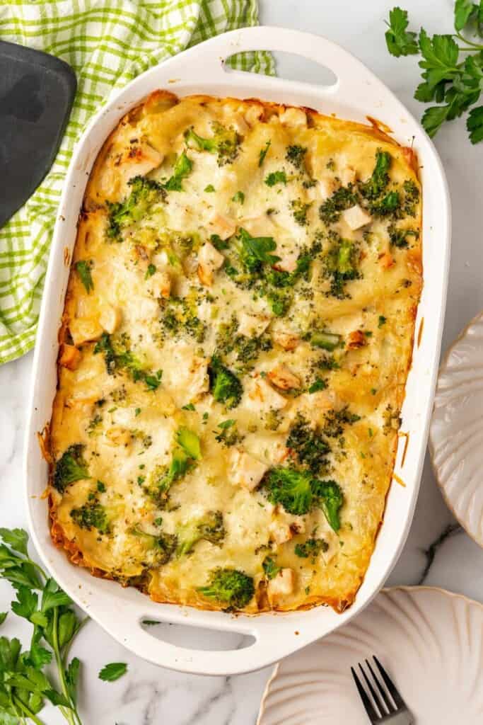 Baked chicken and broccoli pasta in a white 9x13 casserole dish.