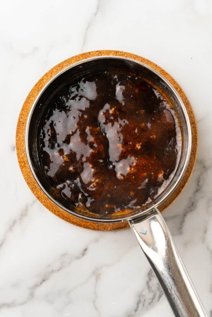 Boiling honey garlic sauce in a small saucepan. 