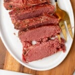 Sliced corned beef on a white plate.