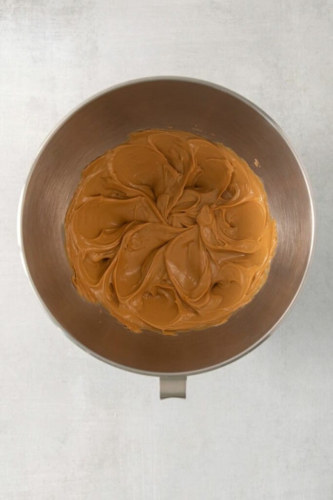 Overhead view of peanut butter in a silver mixing bowl.