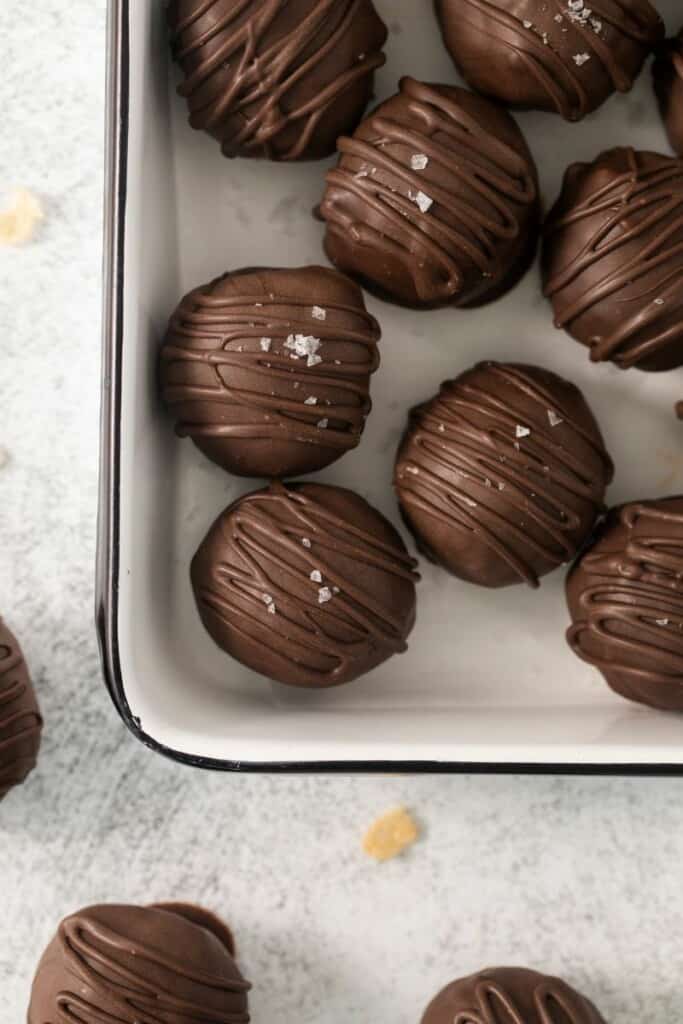 Close up view of chocolate dipped peanut butter balls made with rice krispies.