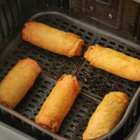 Reheated egg rolls in an air fryer basket