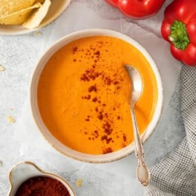 A bowl of prepared smoky red pepper crema with a spoon in it.