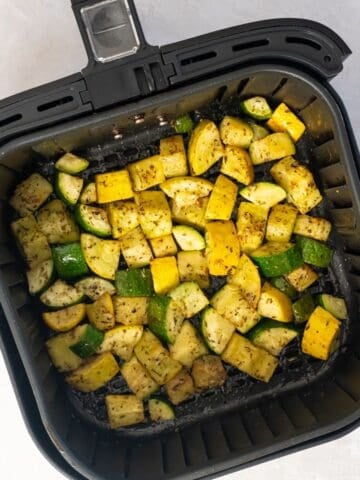 Cooked zucchini and squash in the air fryer basket.
