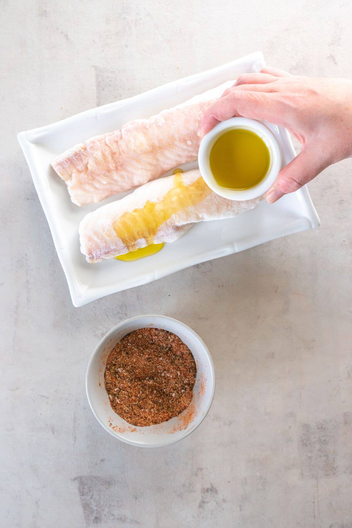 Oil being poured over frozen cod.