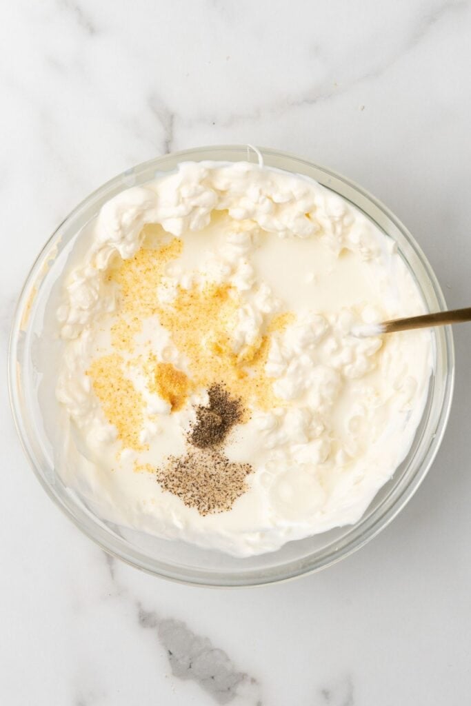 Cream cheese mixture for the green bean casserole with cheese about to be mixed together in a bowl.