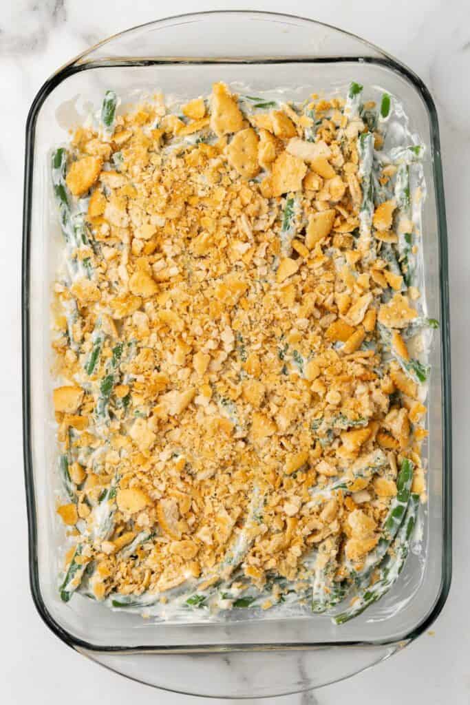 Ritz crackers on top of the homemade green bean casserole about to be baked.