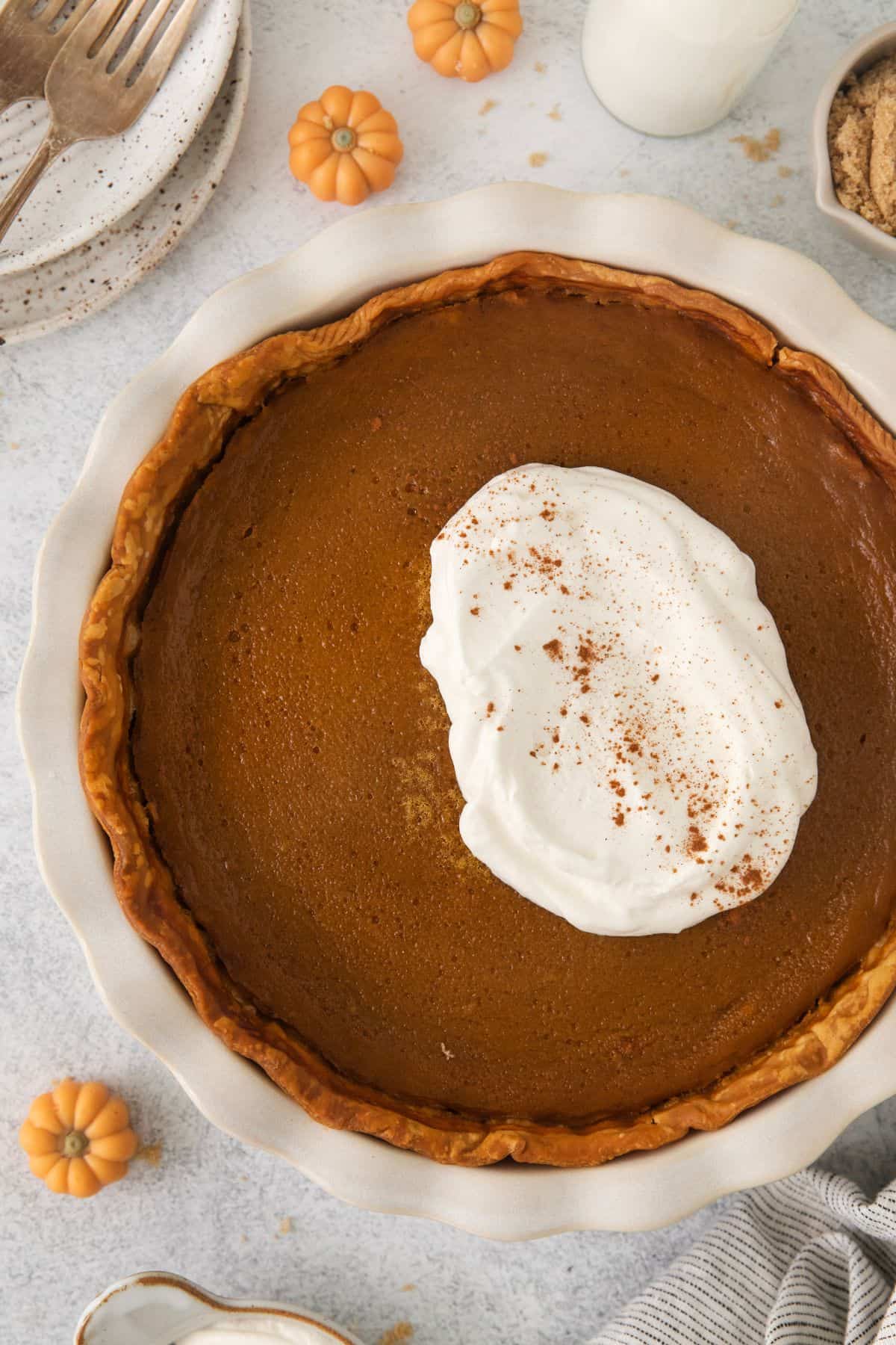 Pumpkin pie without evaporated milk with a big dollop of whipped cream on top.