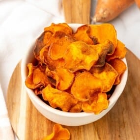 A white bowl filled with sweet potato chips.