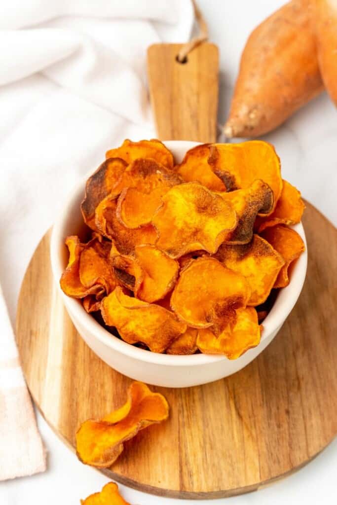 A white bowl filled with sweet potato chips.