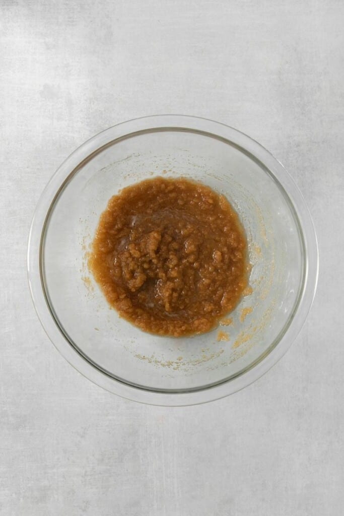 Granulated sugar, brown sugar and browned butter in a clear mixing bowl.