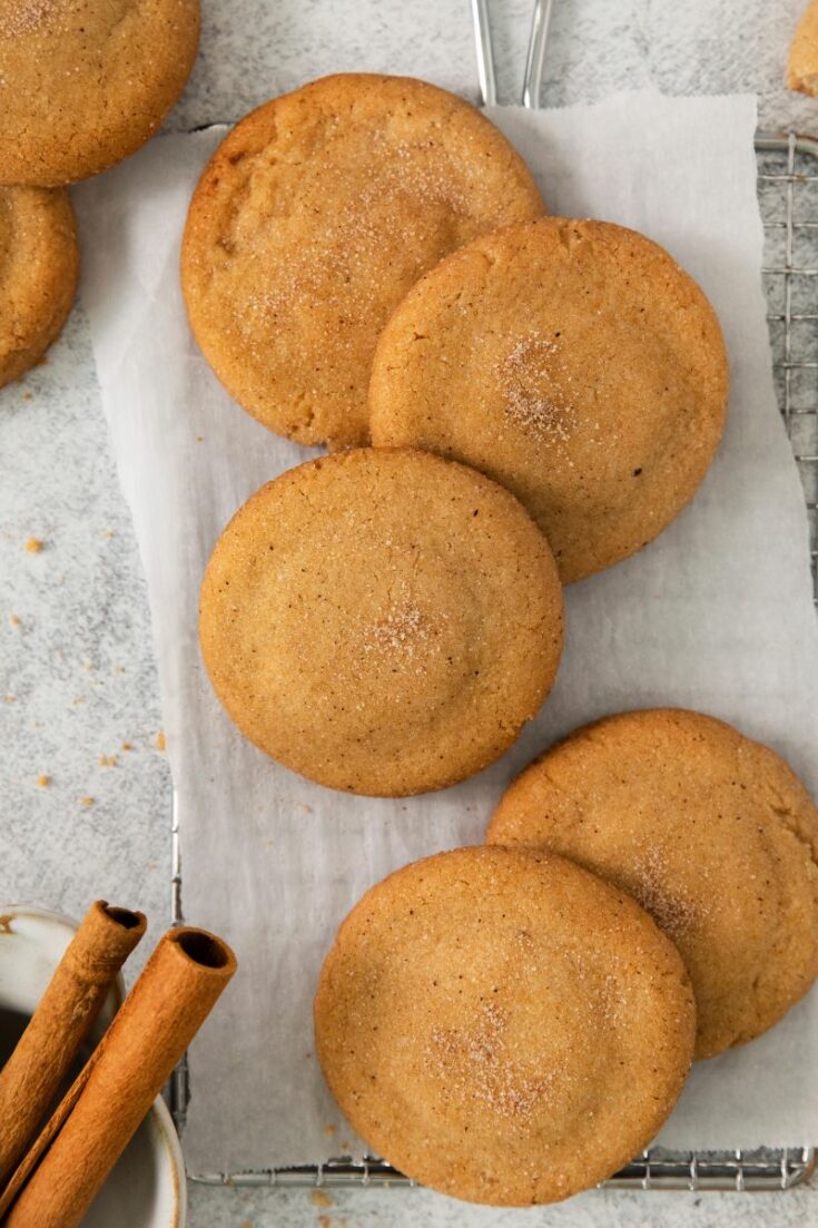 Snickerdoodles with Brown Butter on parchment paper with cinnamon sticks
