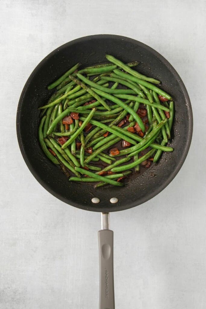Saute green beans with bacon in a small skillet.