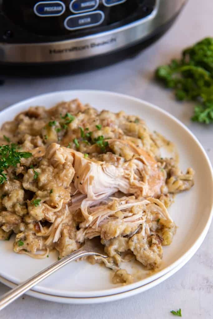 Chicken and stuffing on a plate with a fork holding a bite.