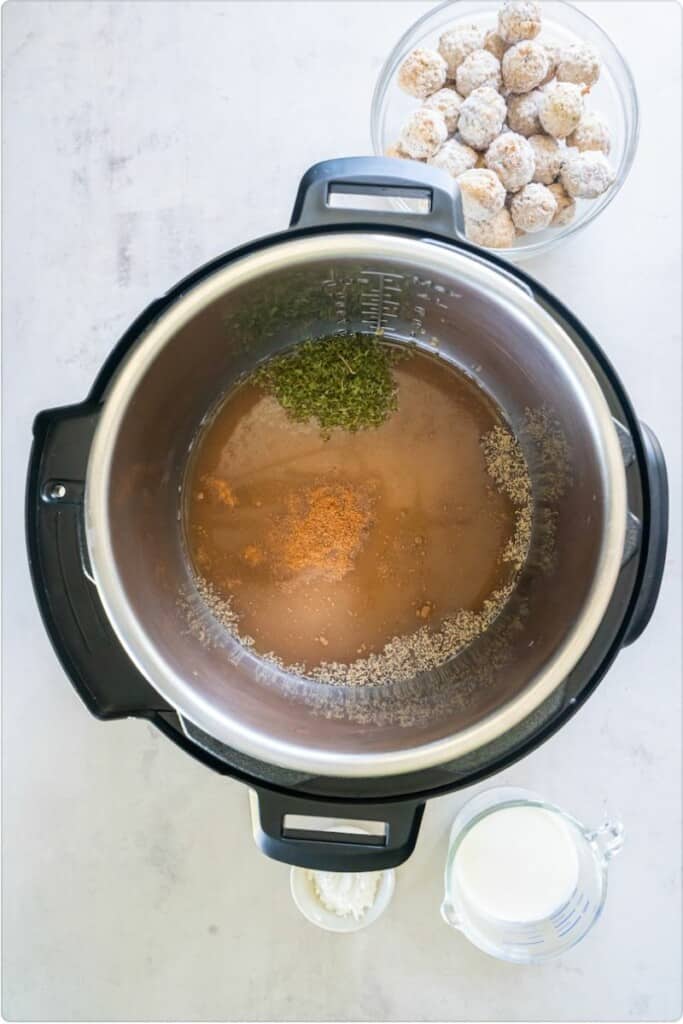 Beef broth, herbs, seasonings and spices in an Instant Pot.