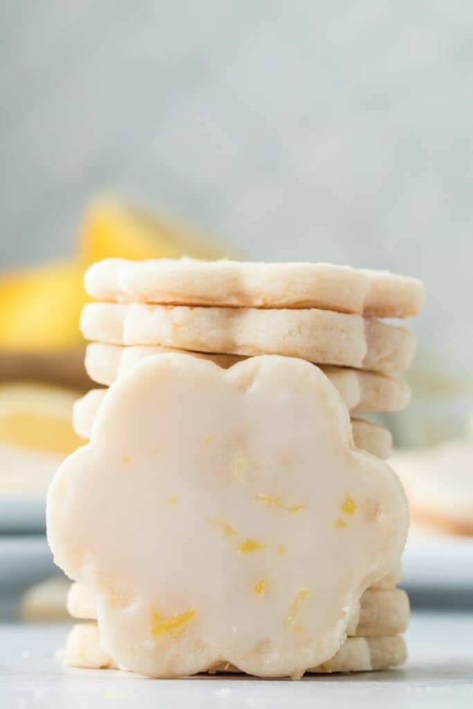 A closeup view of a stack of glazed lemon shortbread cookies.