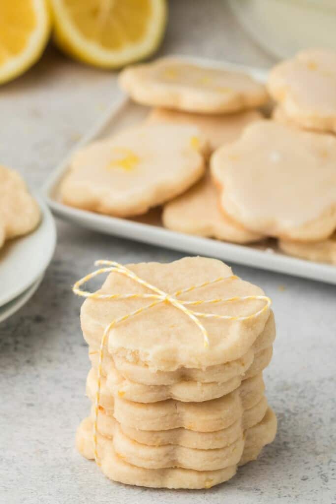 A stack of lemon shortbread cookies with a bow on top of the stack.