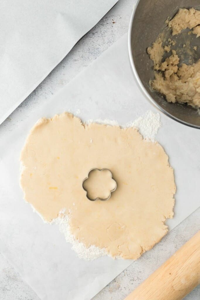 Rolling out cookie dough flat so it can be cut into shapes with cookie cutters.