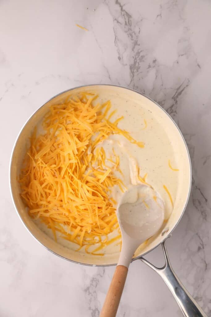 Preparing a roux in a saucepan using a wooden spoon to stir.