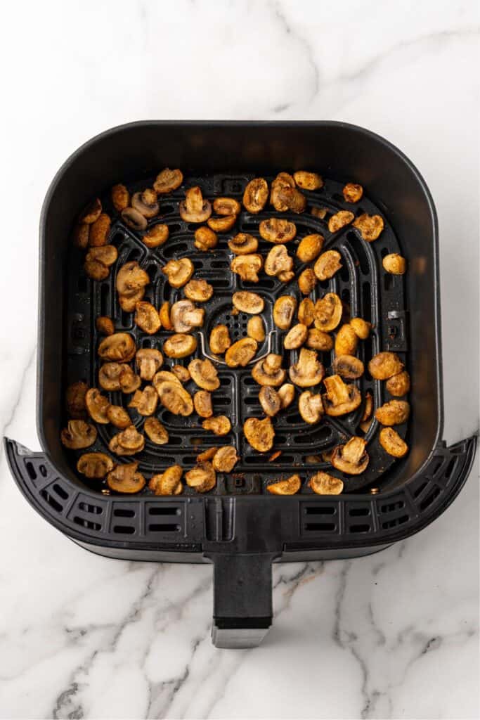 Cooked mushrooms in the air fryer basket.