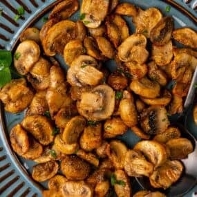 Air fryer mushrooms on a blue serving plate.