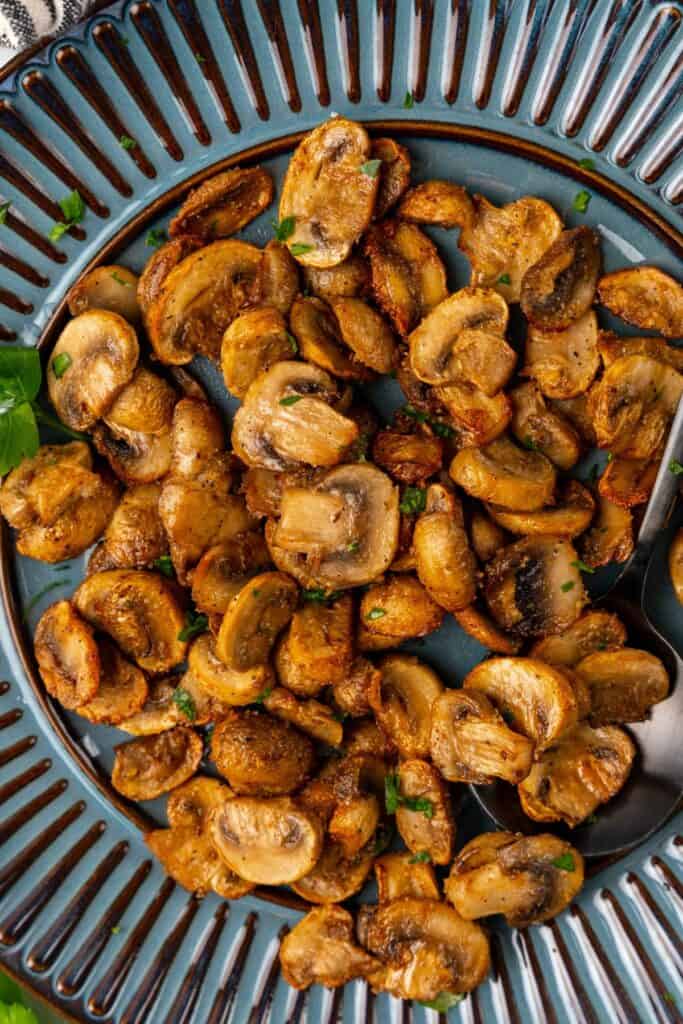 Air fryer mushrooms on a blue serving plate.