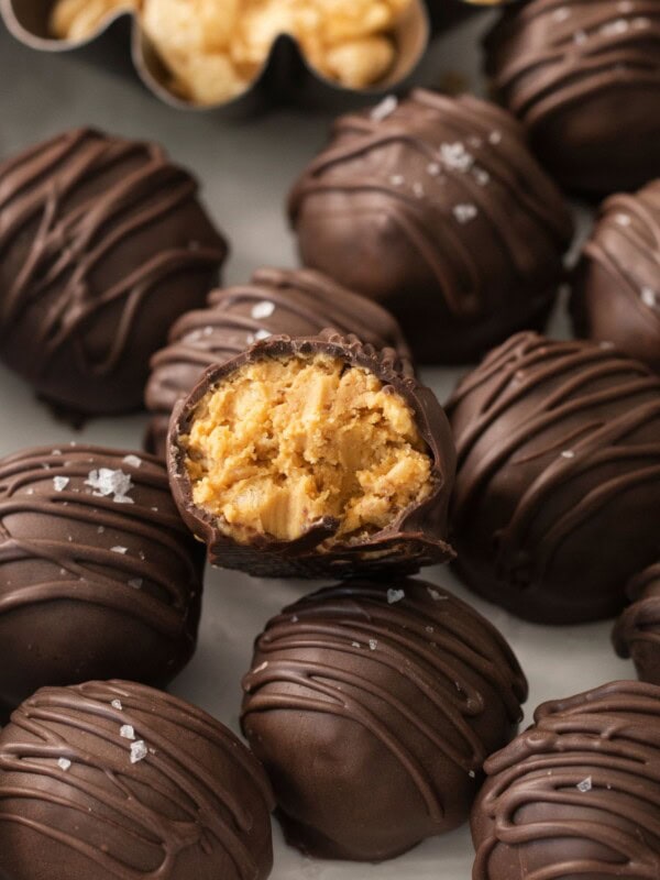 Chocolate peanut butter balls with rice krispies with one with a bite taken out so you can see the inside.