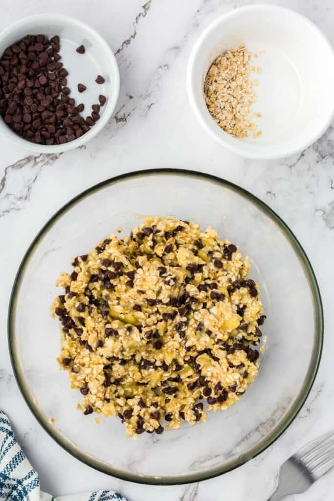 Dough for oatmeal cookies in a clear mixing bowl.