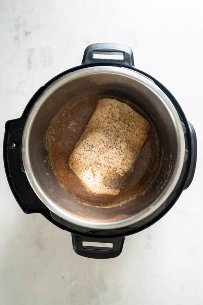 Pork loin with seasonings after being cooked in the instant pot.