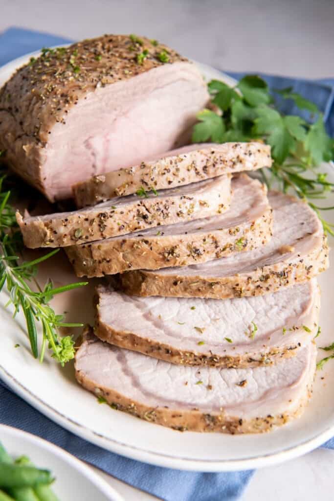 Prepared pork loin cut into slices on a plate.