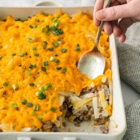 Hash brown casserole with a piece taken out and a spoon