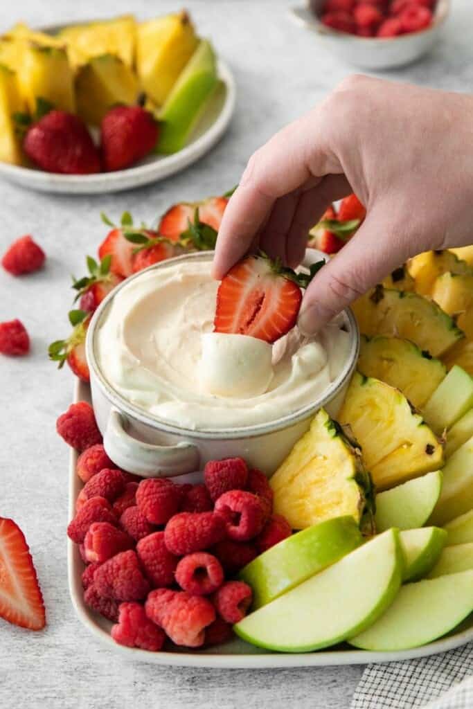 Dipping a strawberry in marshmallow dip for fruit.