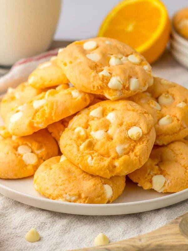 Orange creamsicle cookies with white chocolate chips stacked on top of each other