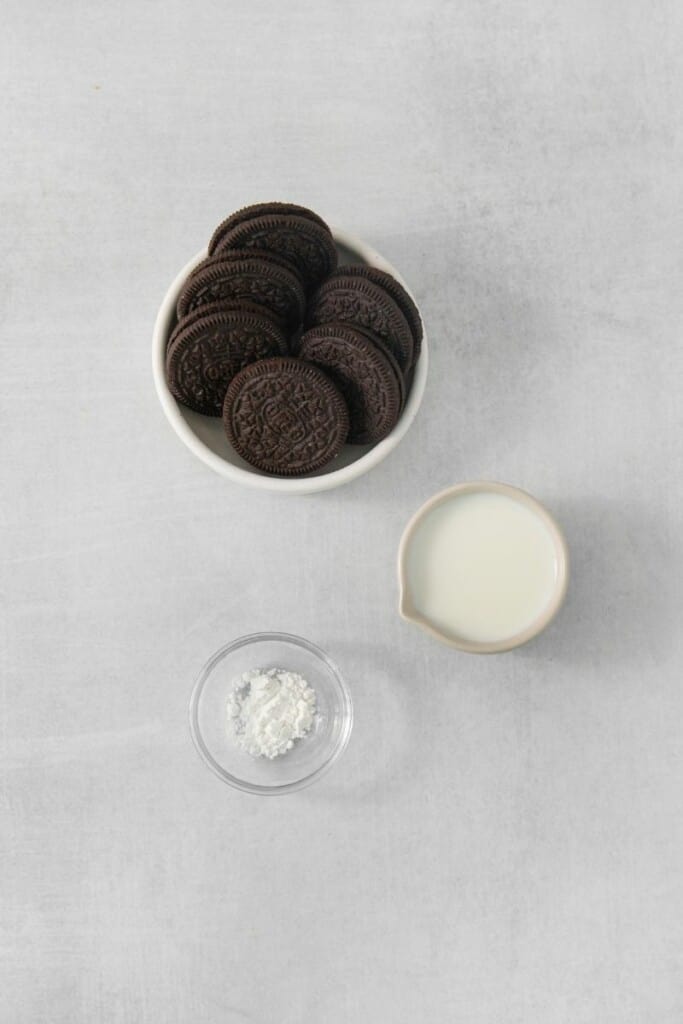 Ingredients needed to prepare an oreo cake in a mug.
