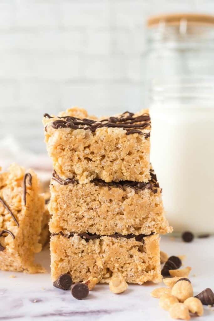 Three vertically stacked rice krispie treats drizzled with chocolate.