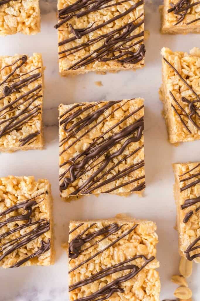 Chocolate drizzled peanut butter rice krispie treats cut into squares.