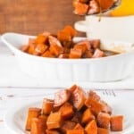 A plate of candied sweet potatoes with a spoon holding one bite above the plate.