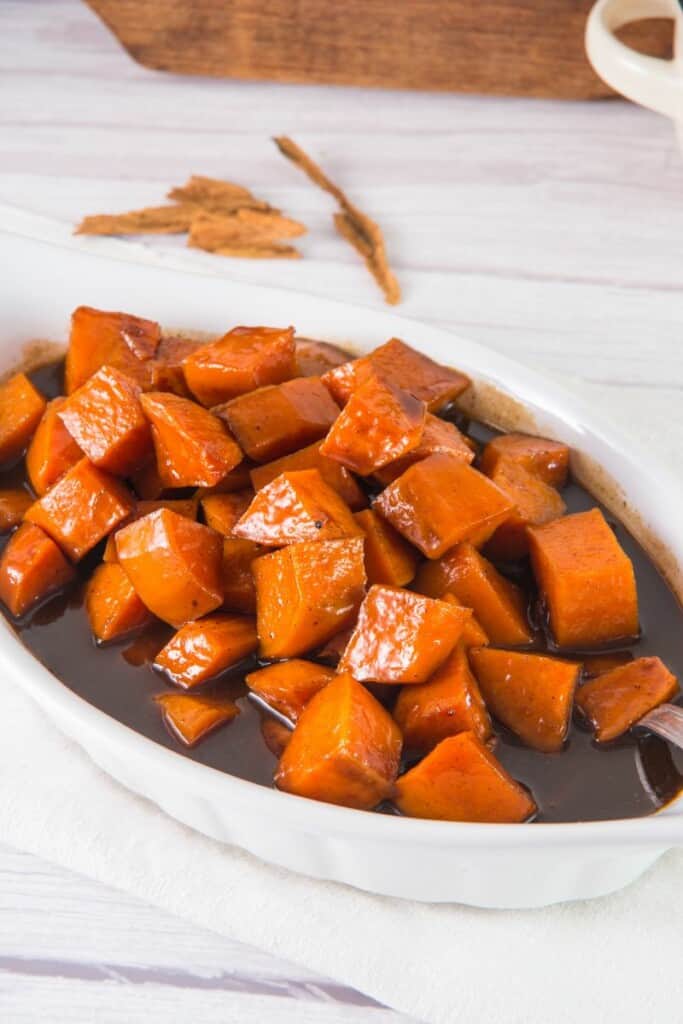 Closeup view of candied sweet potatoes in a serving dish.