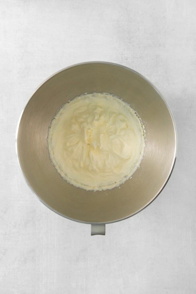 Combining heavy cream and vanilla pudding mix in a mixing bowl.