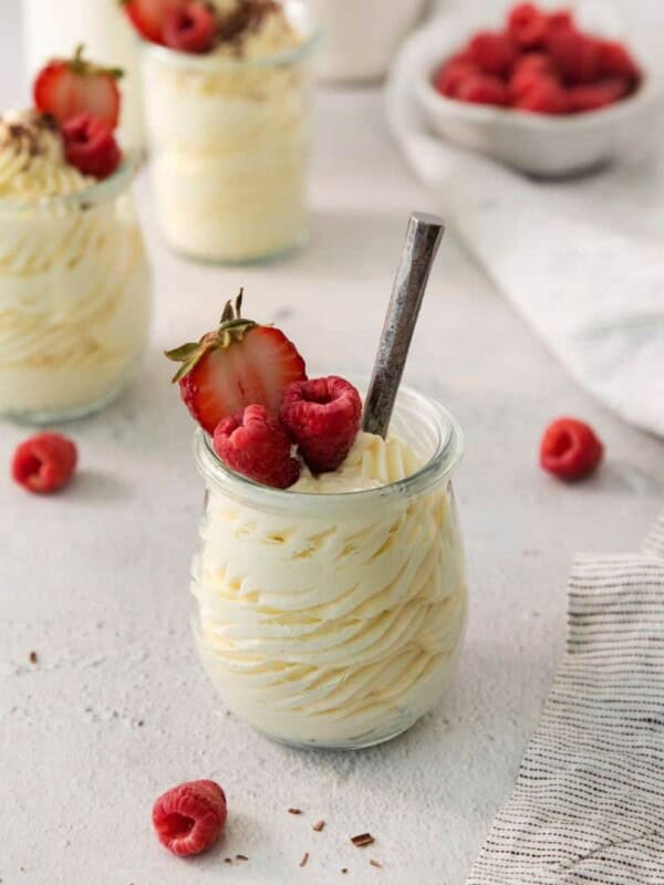 A serving bowl of vanilla mousse topped with fresh berries.