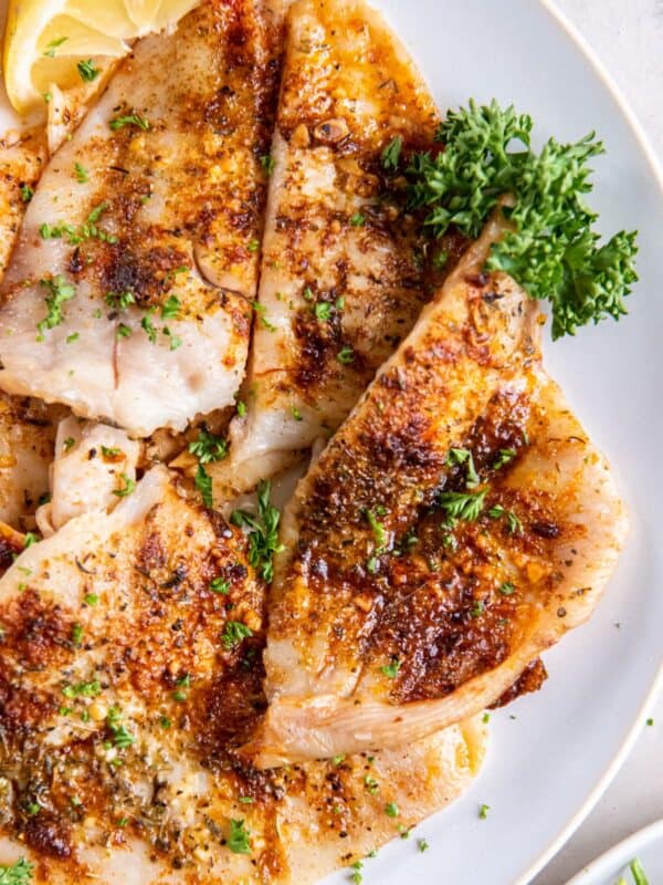 Air fryer flounder fillets on a white plate.