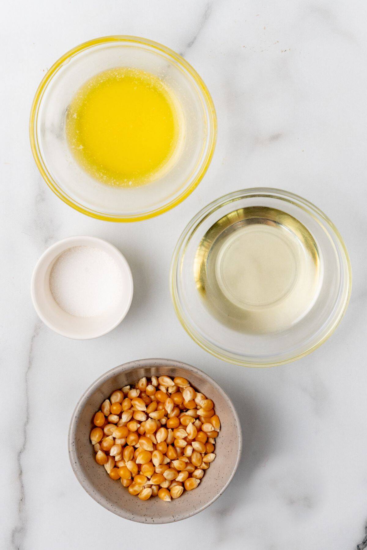 Ingredients needed to make air fryer popcorn: popcorn kernels, oil, butter, and salt.
