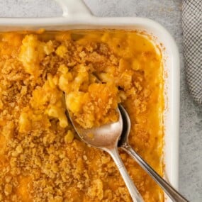 Closeup of macaroni casserole in a baking dish with 2 spoons