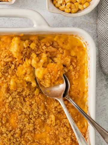 Closeup of macaroni casserole in a baking dish with 2 spoons