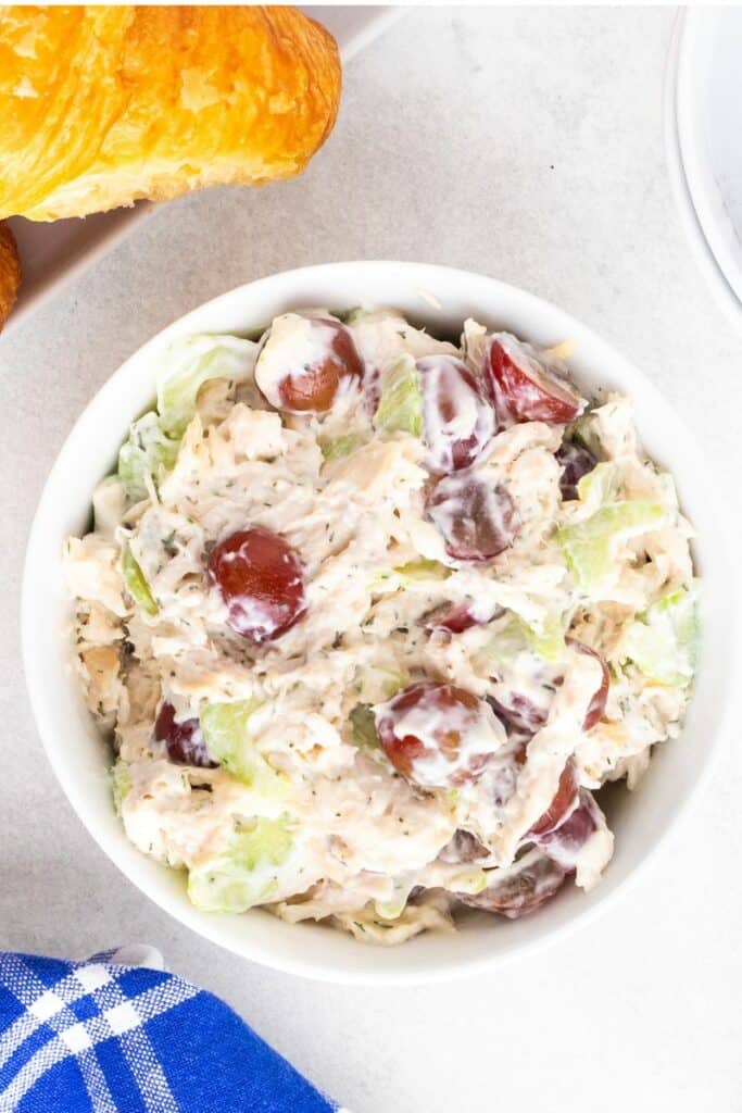 An close up overhead view of chicken salad in a white bowl.