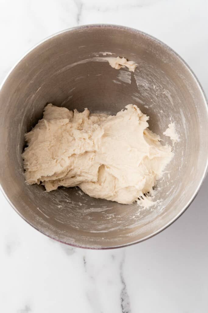 Combining ingredients in mixing bowl, adding more flour as needed.