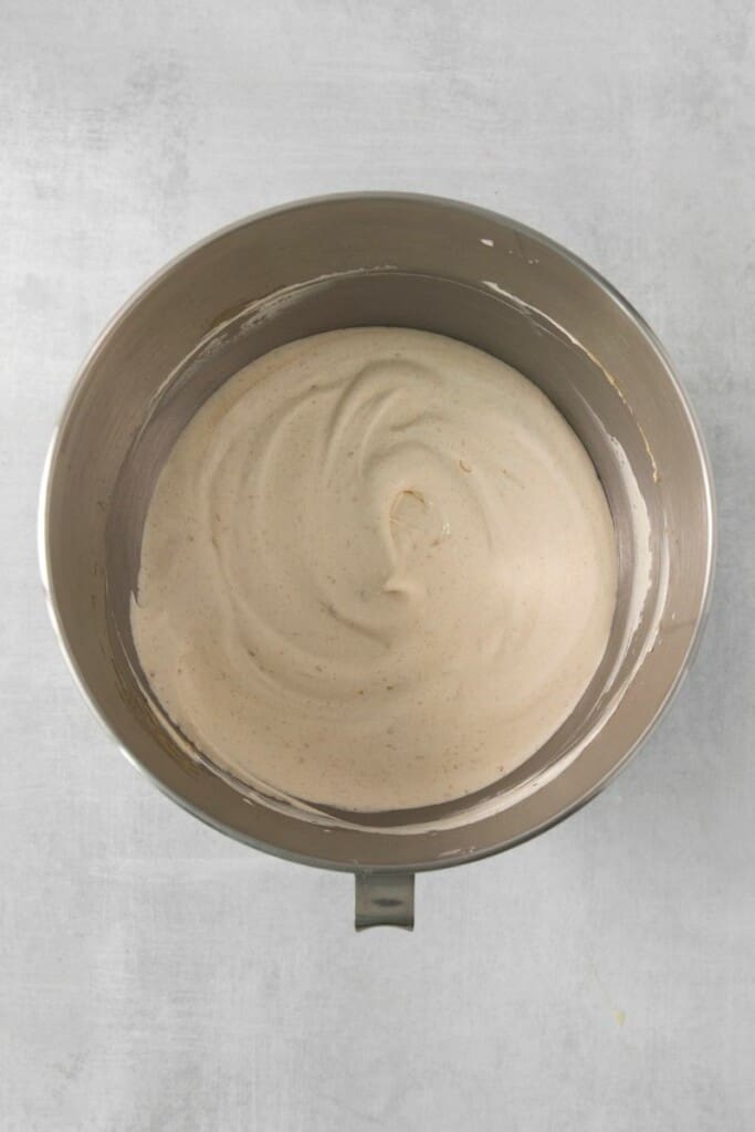 Adding whipped cream to peanut butter mixture in a mixing bowl.